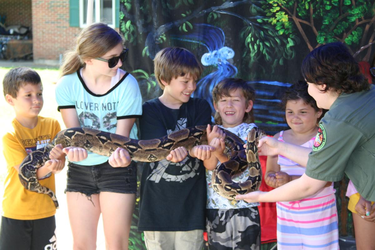 Children holding a snake
